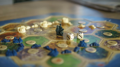 An RPG game set up on a table, with a game board, miniatures, tokens, and dice arranged for play.